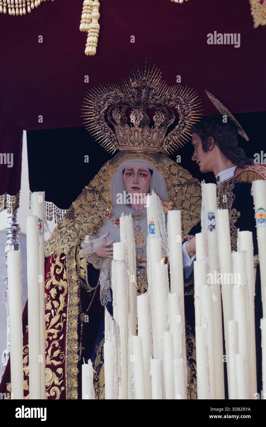Gros plan de la Vierge de Patrocinio avec Saint Jean l'évangéliste, sous la canopée, sur son trône processionnel. Les points forts incluent la couronne dorée Banque D'Images