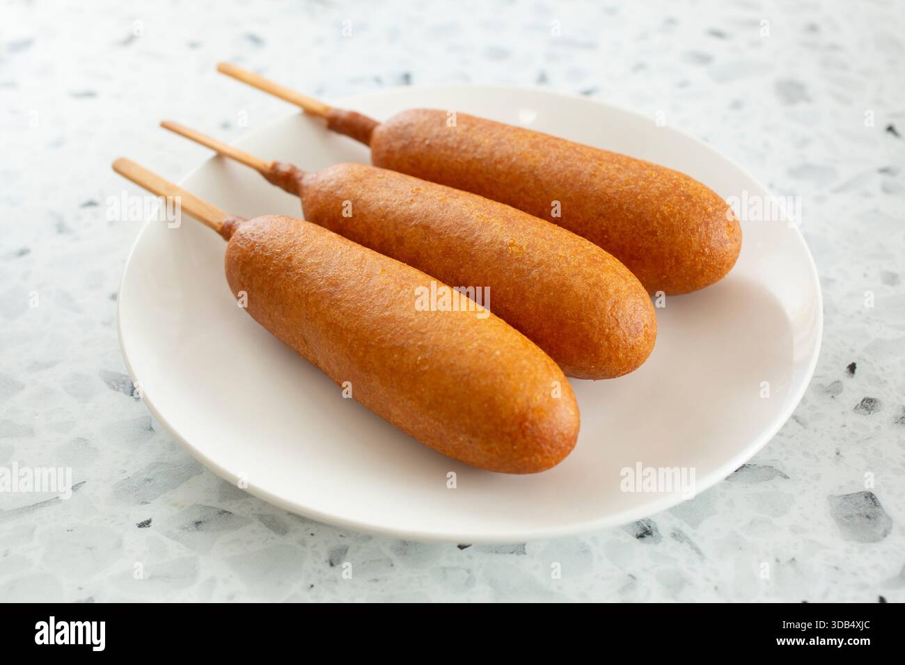 Une vue de trois chiens de maïs sur une assiette. Banque D'Images