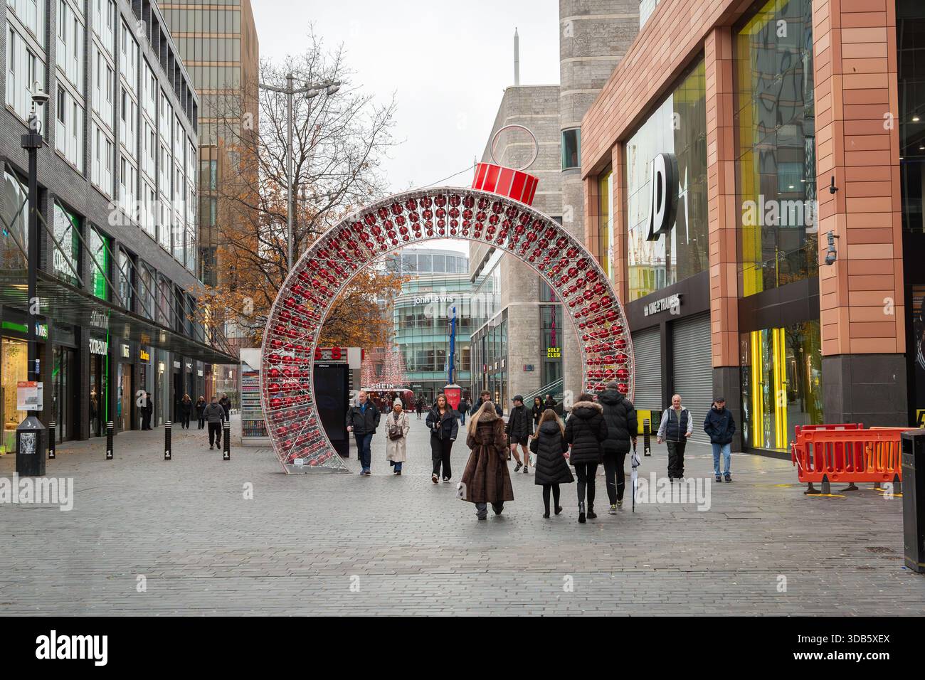 Liverpool, Royaume-Uni, 7 décembre 2025 : exposition de Noël dans la zone commerçante de Paradise Street. Piétons marchant à travers une passerelle géante en forme de boule. Banque D'Images