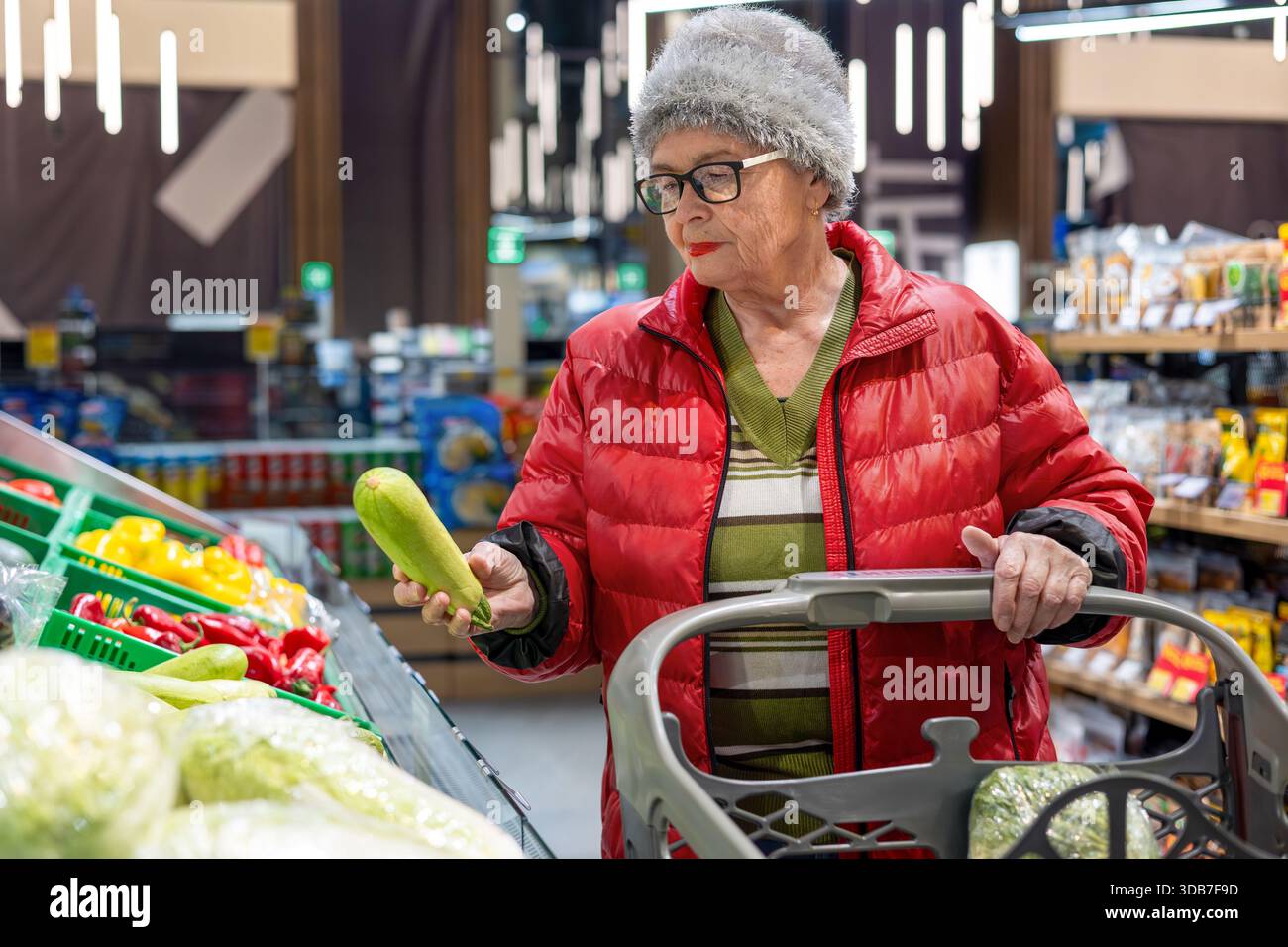 Petit-fils apprenant à sa grand-mère à utiliser la balance libre-service numérique à l'épicerie. Gen Alpha aide un baby-boom, la culture numérique Banque D'Images