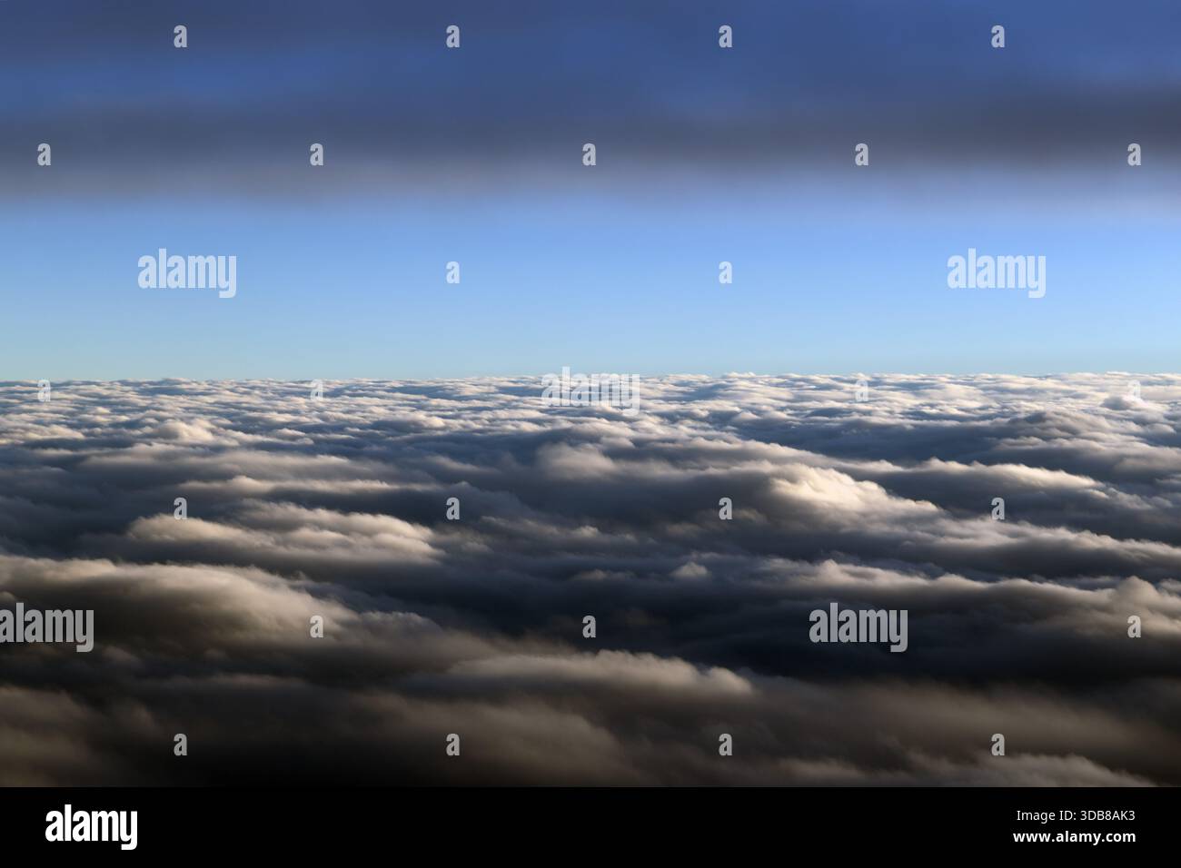 Une couche de nuages s'étend à travers l'horizon comme vu d'un avion en vol au-dessus des sommets des nuages. Banque D'Images