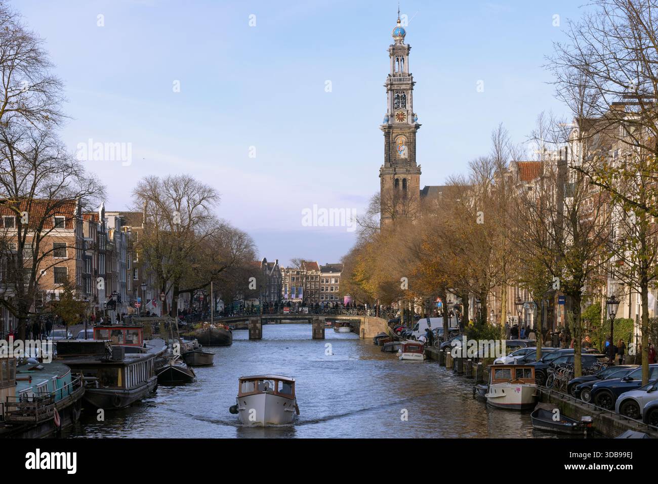 Amsterdam, pays-Bas - 22 novembre 2025 : pittoresque du canal Prinsengracht avec bateau touristique et tour de l'église Westerkerk le jour du printemps. Banque D'Images