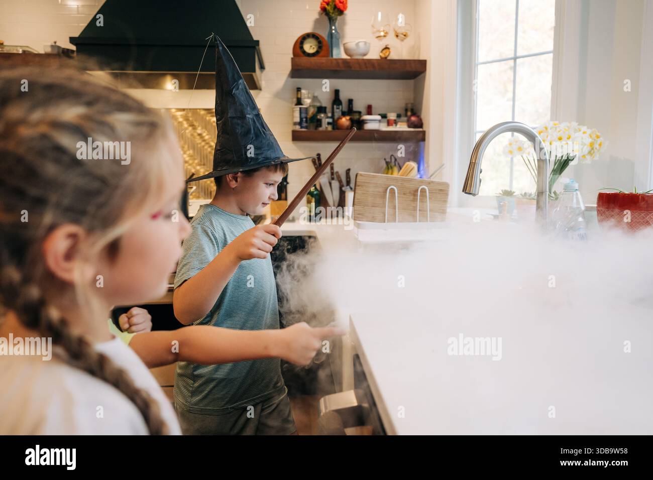 Enfants jouant à un jeu magique avec de la fumée de glace sèche Banque D'Images