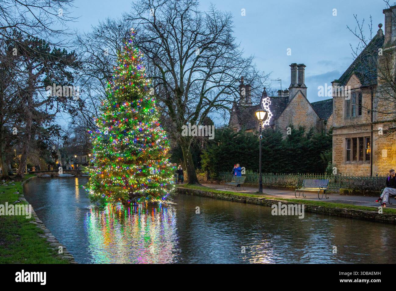 Arbre de noël flottant décoré avec des lumières, sur la rivière Windrush comme il passe à travers le village Cotswold de Bourton sur l'eau Gloucestershire Banque D'Images