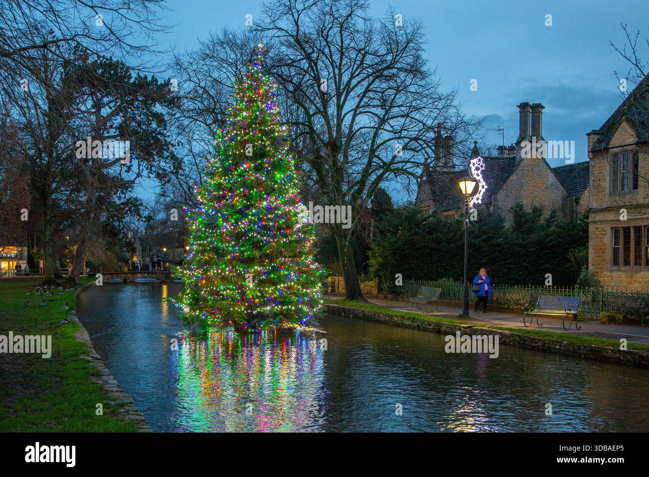 Arbre de noël flottant décoré avec des lumières, sur la rivière Windrush comme il passe à travers le village Cotswold de Bourton sur l'eau Gloucestershire Banque D'Images