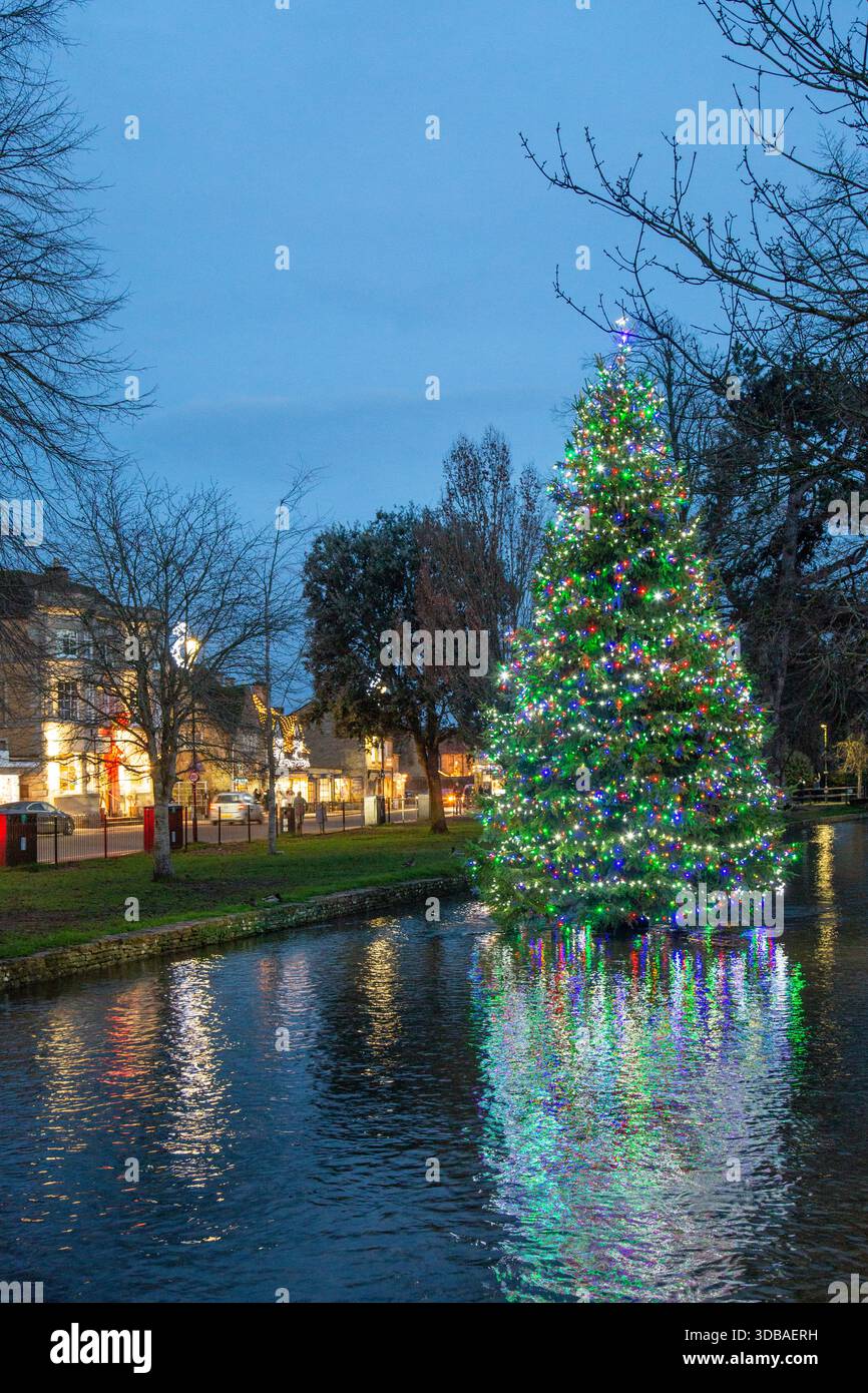 Arbre de noël flottant décoré avec des lumières, sur la rivière Windrush comme il passe à travers le village Cotswold de Bourton sur l'eau Gloucestershire Banque D'Images