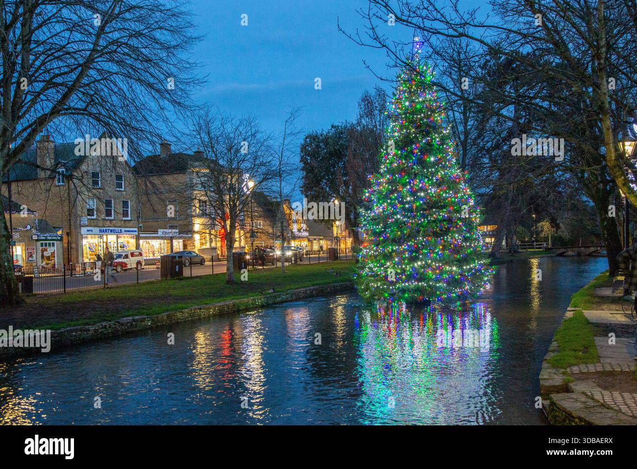 Arbre de noël flottant décoré avec des lumières, sur la rivière Windrush comme il passe à travers le village Cotswold de Bourton sur l'eau Gloucestershire Banque D'Images