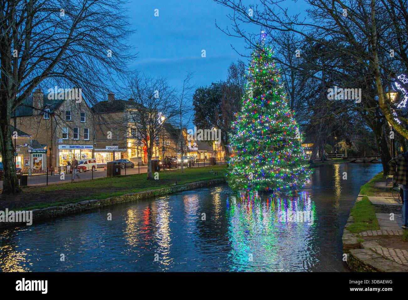 Arbre de noël flottant décoré avec des lumières, sur la rivière Windrush comme il passe à travers le village Cotswold de Bourton sur l'eau Gloucestershire Banque D'Images