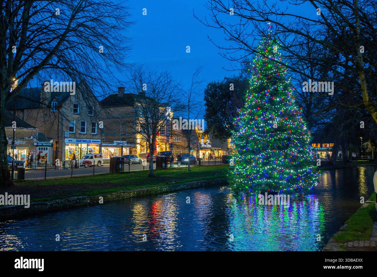 Arbre de noël flottant décoré avec des lumières, sur la rivière Windrush comme il passe à travers le village Cotswold de Bourton sur l'eau Gloucestershire Banque D'Images