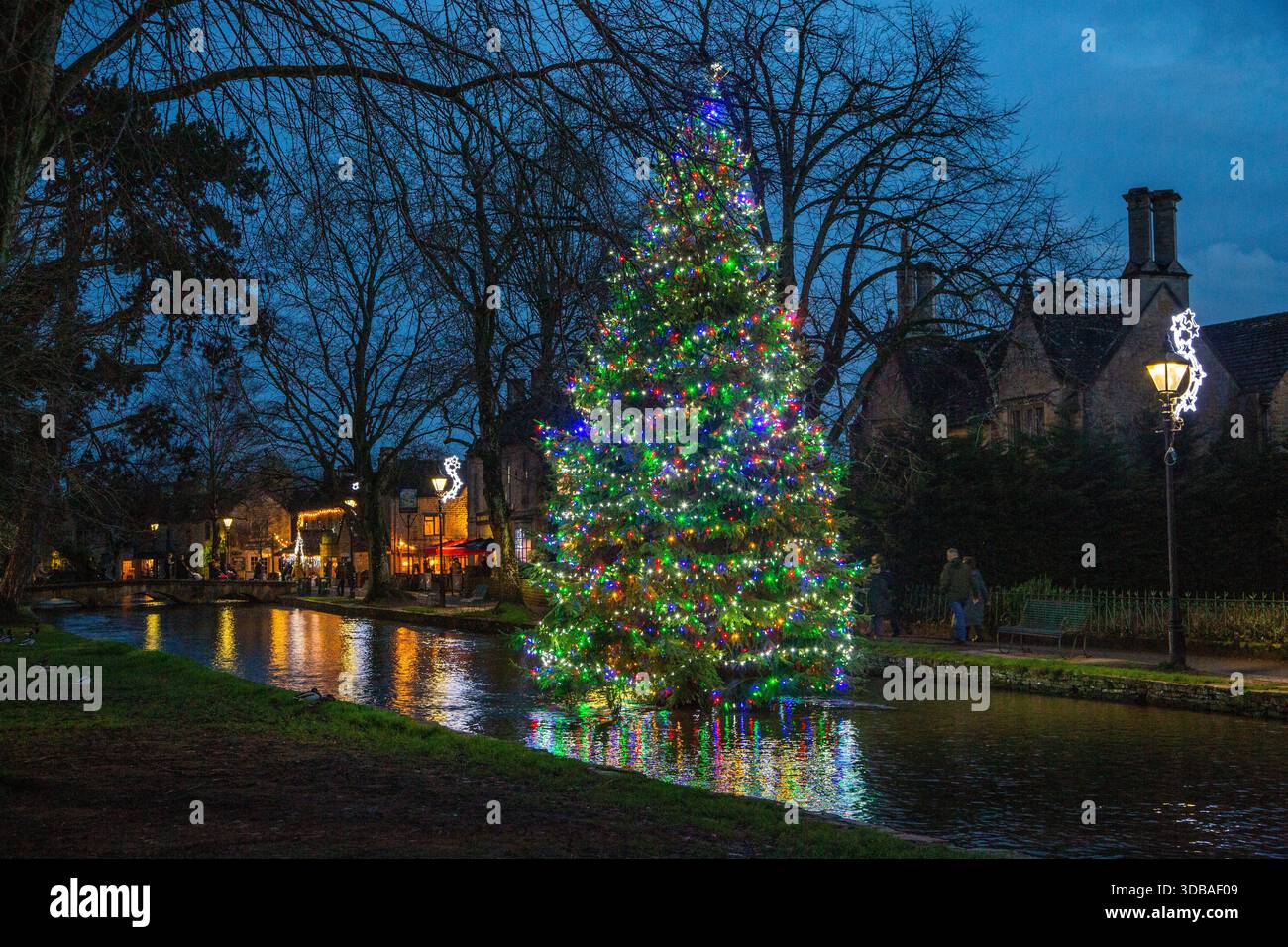 Arbre de noël flottant décoré avec des lumières, sur la rivière Windrush comme il passe à travers le village Cotswold de Bourton sur l'eau Gloucestershire Banque D'Images