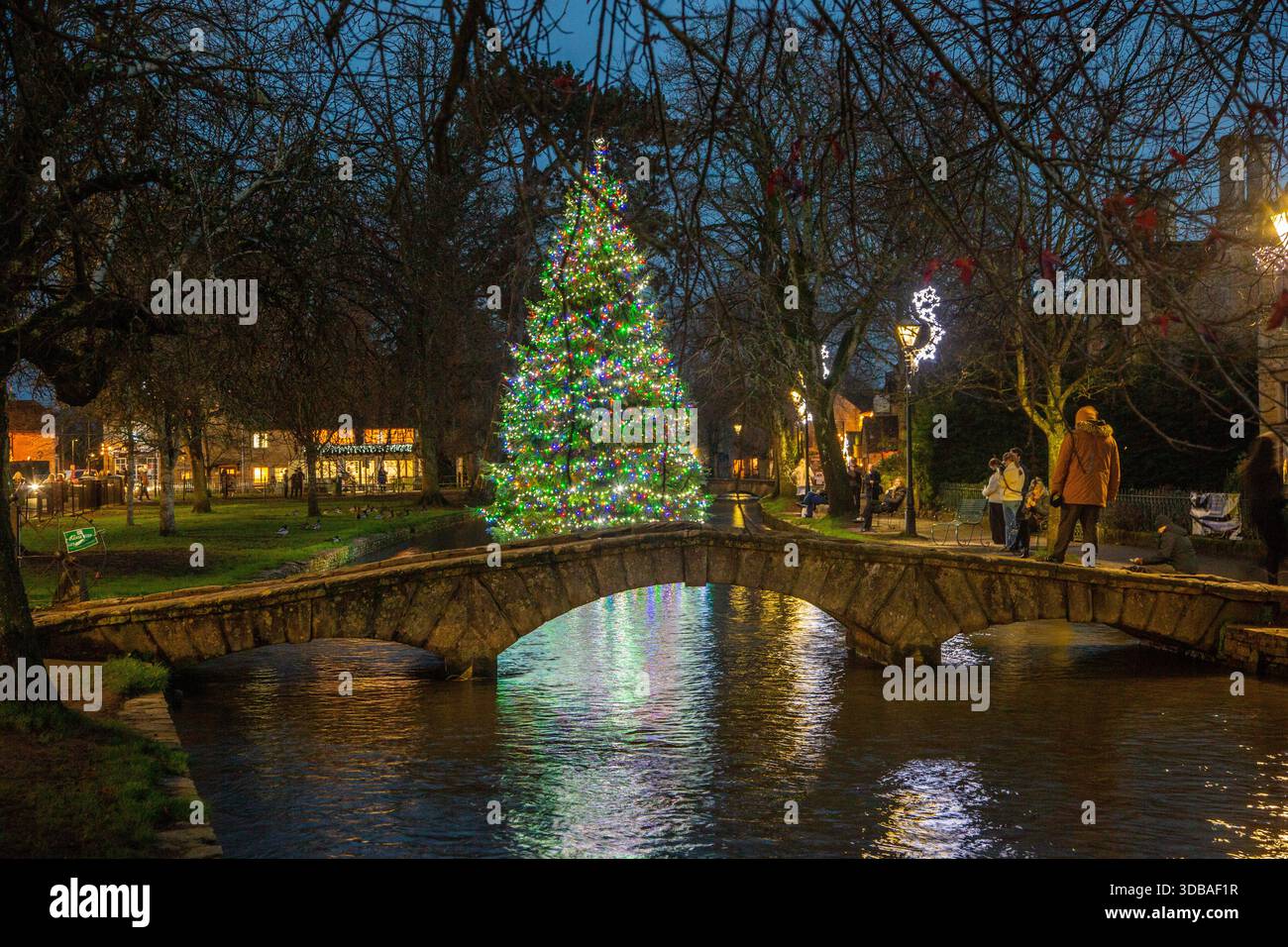 Arbre de noël flottant décoré avec des lumières, sur la rivière Windrush comme il passe à travers le village Cotswold de Bourton sur l'eau Gloucestershire Banque D'Images