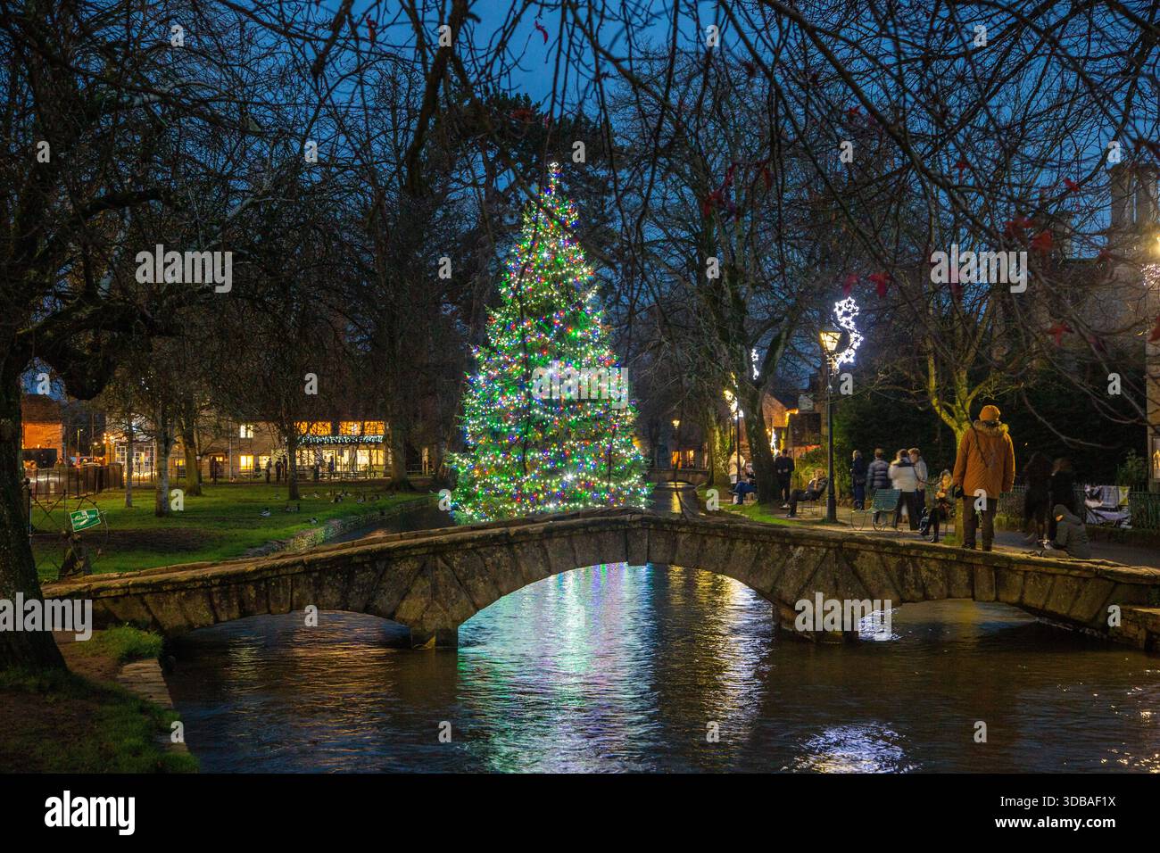 Arbre de noël flottant décoré avec des lumières, sur la rivière Windrush comme il passe à travers le village Cotswold de Bourton sur l'eau Gloucestershire Banque D'Images