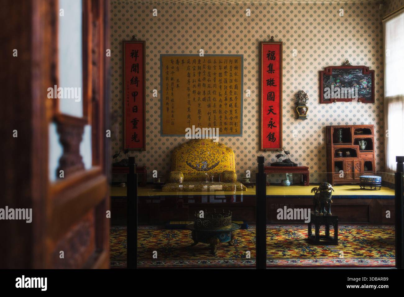 Vue sur une chambre richement décorée avec trône doré, calligraphie chinoise traditionnelle et riches textures créant une scène d'opulen historique Banque D'Images