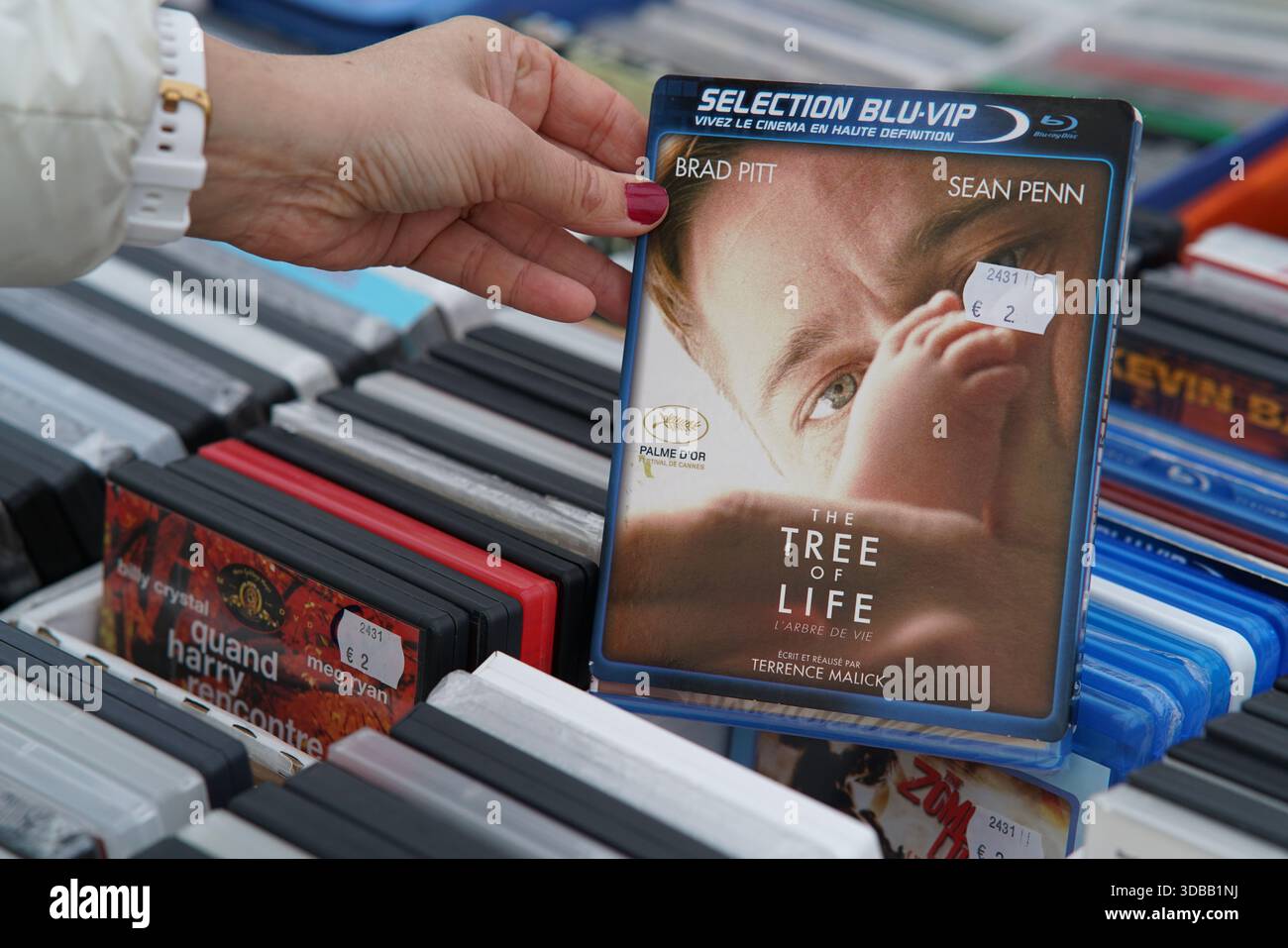 Personne choisissant un étui Blu-ray à partir de boîtes de films d'occasion à une table de marché en plein air.Nantes, France Banque D'Images