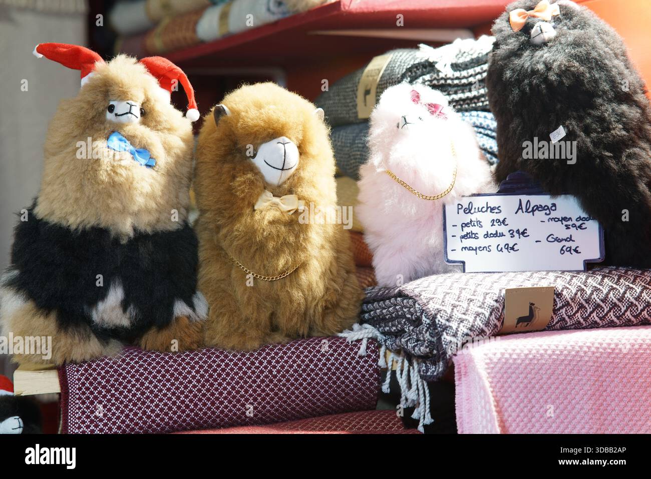 Sélection de jouets en peluche d'alpaga moelleux exposés à la vente sur un stand de marché.Nantes, France Banque D'Images