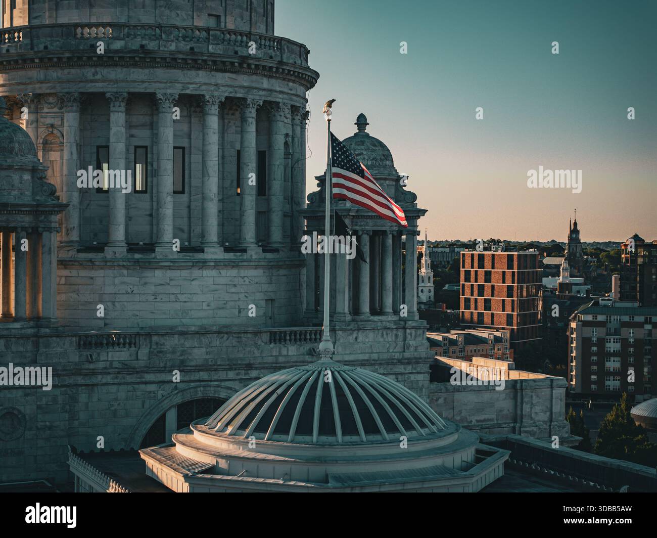 Vue aérienne de la Rhode Island State House, son dôme brille doucement contre la ligne d'horizon, avec le drapeau américain agitant fièrement au-dessus, Providence, Rho Banque D'Images