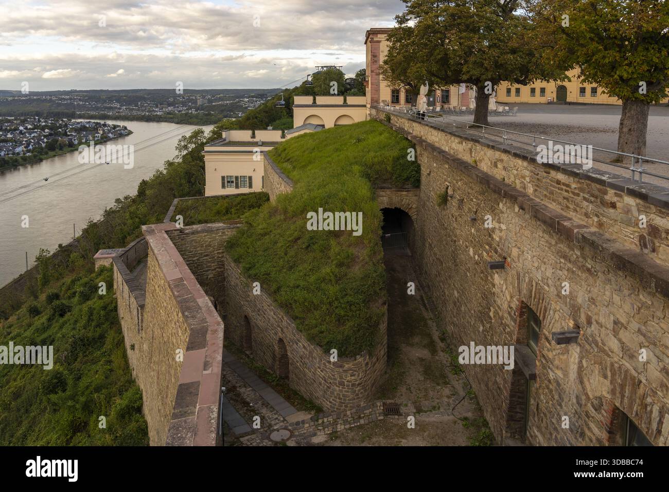 Vue sur les murs de la forteresse et la verdure luxuriante surplombant la rivière sous un ciel spectaculaire, un moment serein capturé dans la forteresse d'Ehrenbreitstein, Coblence Banque D'Images