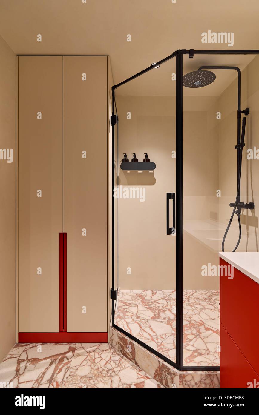 Douche moderne et élégante, lavabo, salle de bains luxueuse avec douche en verre et touches rouges vives Banque D'Images