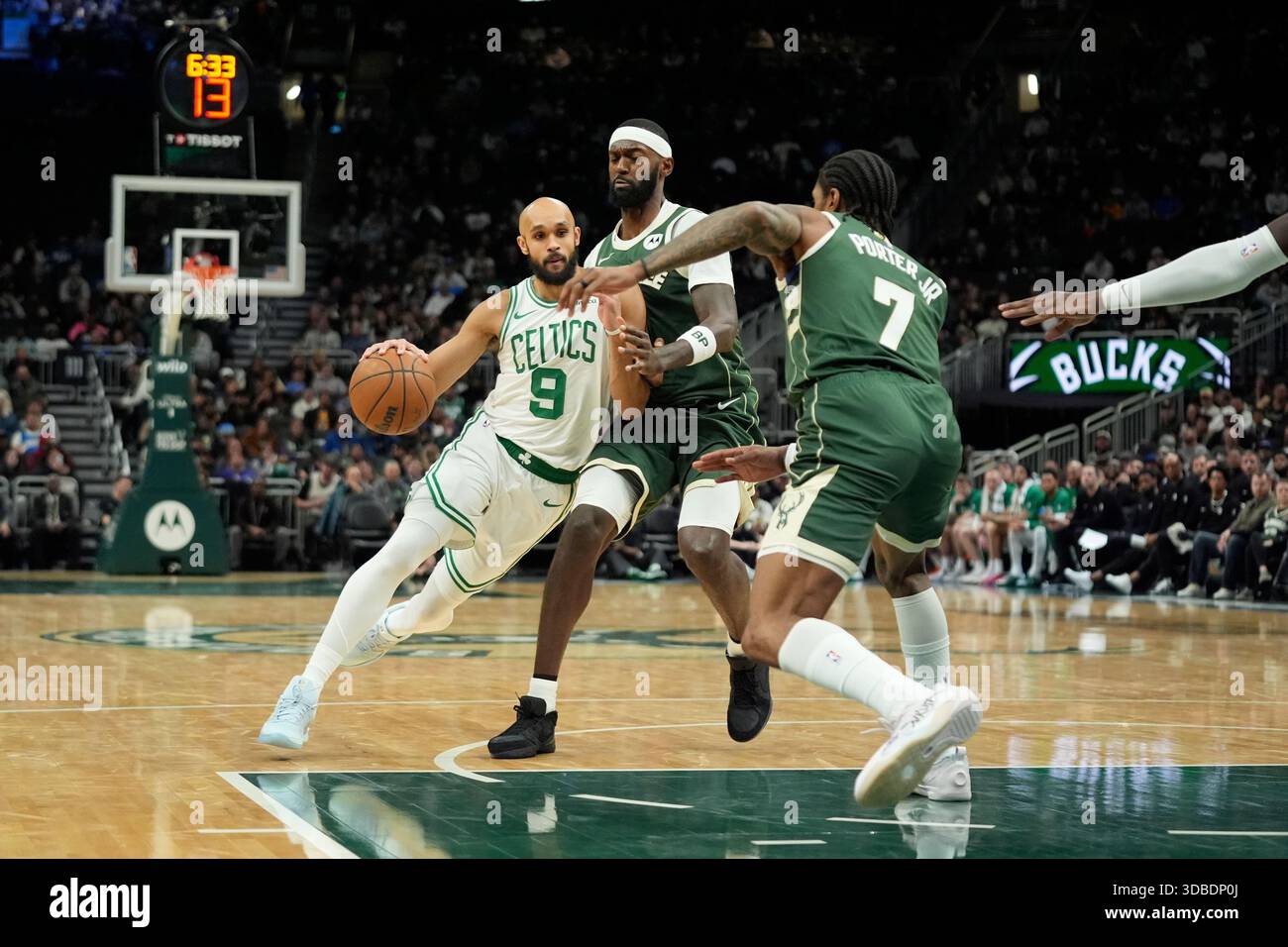 Boston Celtics' Derrick White drives to the basket against Milwaukee Bucks' Kevin Porter Jr. and Bobby Portis during an NBA basketball game Thursday, Dec. 11, 2025, in Milwaukee. (AP Photo/Aaron Gash) Banque D'Images