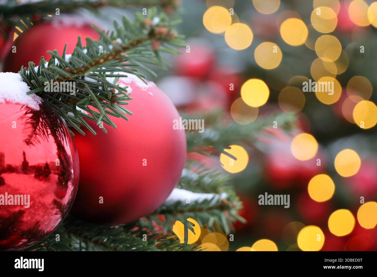 Arbre de Noël avec boules de jouet rouges et illumination festive, lumières dorées sur fond. Arbre du nouvel an avec des jouets Banque D'Images