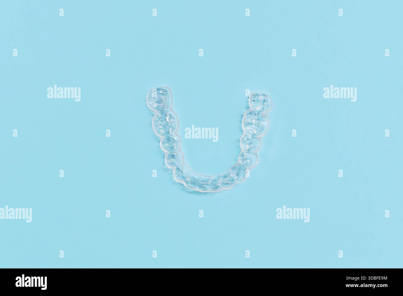 Vue de dessus de dents dentaires transparentes personnalisées protège-morsures aligners clairs pour la mâchoire inférieure sur fond bleu Banque D'Images