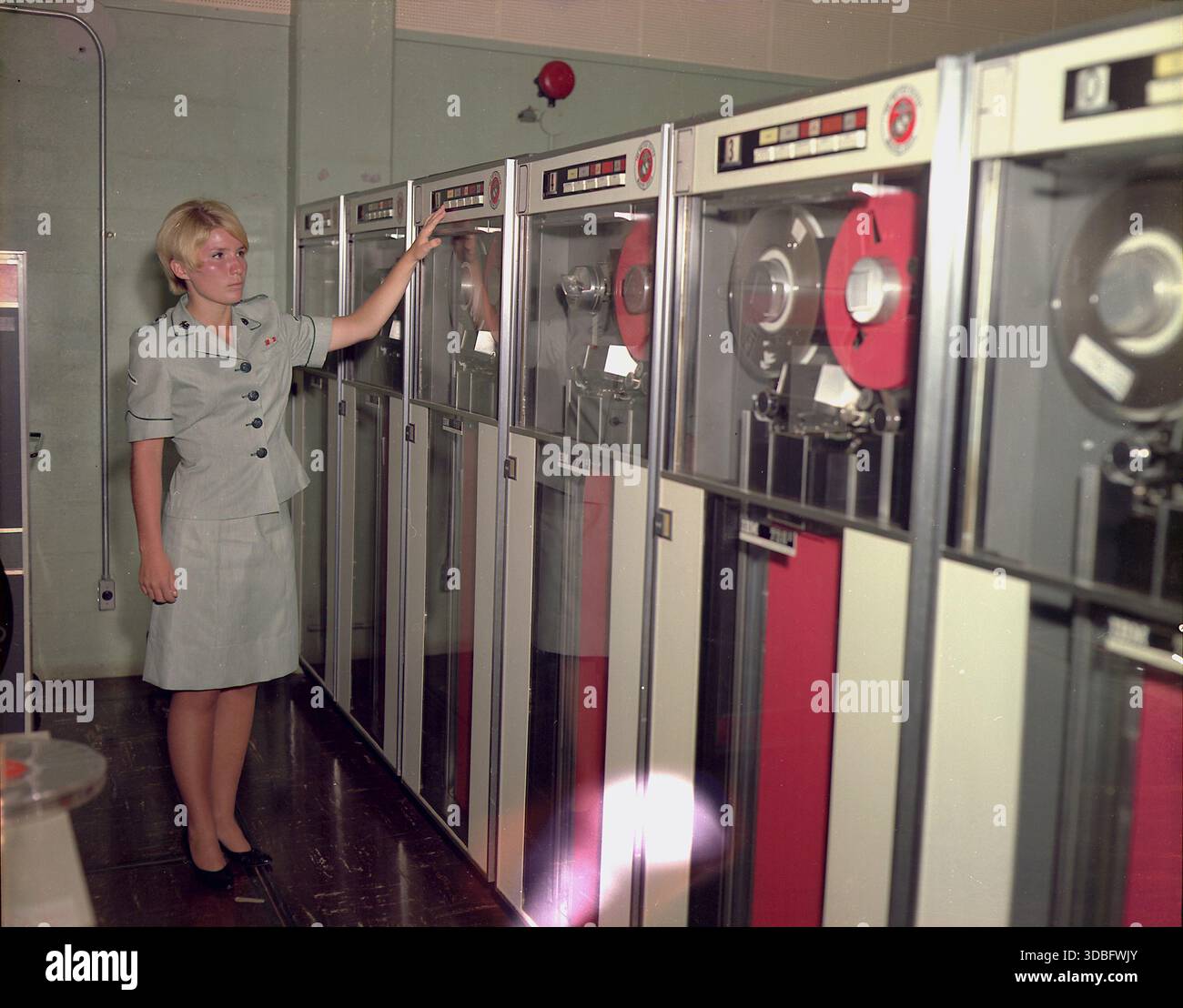 Photographie de PFC Patricia Barbeau à Camp Smith, Hawaï, travaillant sur un lecteur de bande IBM 729. L'image illustre le rôle du personnel militaire dans l'exploitation de l'équipement informatique précoce et l'intégration de la technologie dans les opérations militaires. Banque D'Images