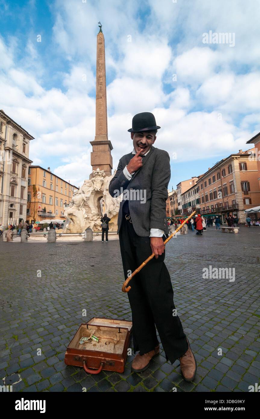 Un jeune artiste de rue imite Charlie Chaplin sur la Piazza Navona, Rome. Banque D'Images