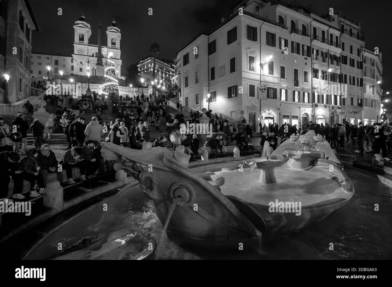 Touristes lors d'un soir de Noël sur la Piazza di Spagna à Rome avec la barchetta de Pietro Bernini au premier plan. Banque D'Images