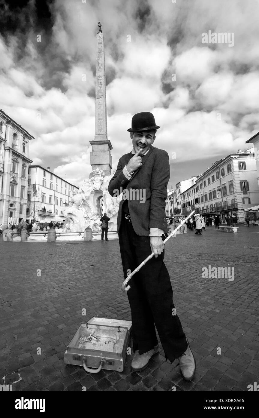 Un jeune artiste de rue imite Charlie Chaplin sur la Piazza Navona, Rome. Banque D'Images