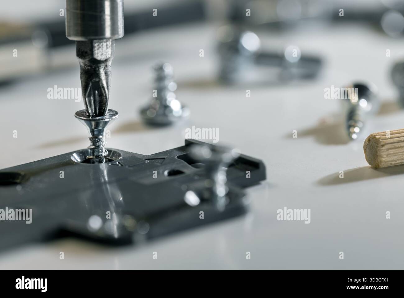 Fabrication et assemblage de meubles. Vissage d'un raccord au matériau MDF Banque D'Images