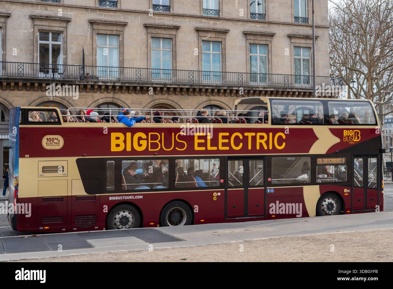 Touristes dans un bus touristique électrique dans le centre-ville de Paris. Les touristes peuvent monter ou descendre à n'importe lequel de leurs arrêts. Banque D'Images