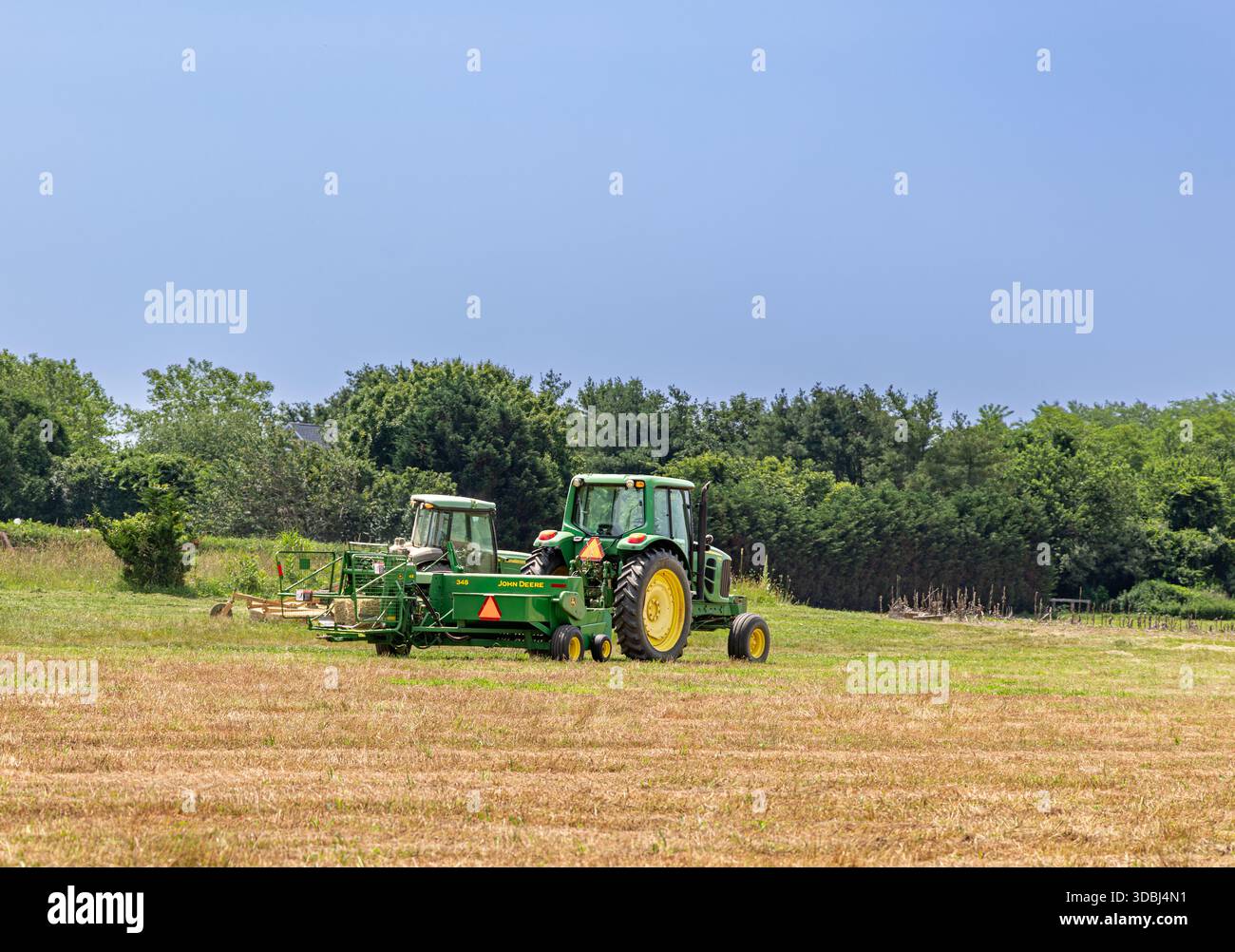 deux tracteurs john deere travaillant dans un champ dans l'est de long island Banque D'Images