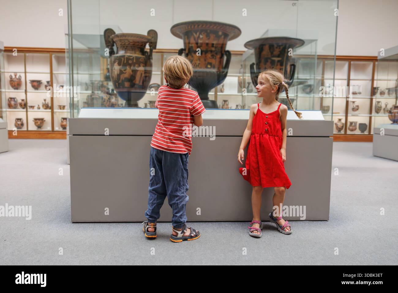 Enfants voyageurs explorent la poterie grecque antique dans un musée Banque D'Images