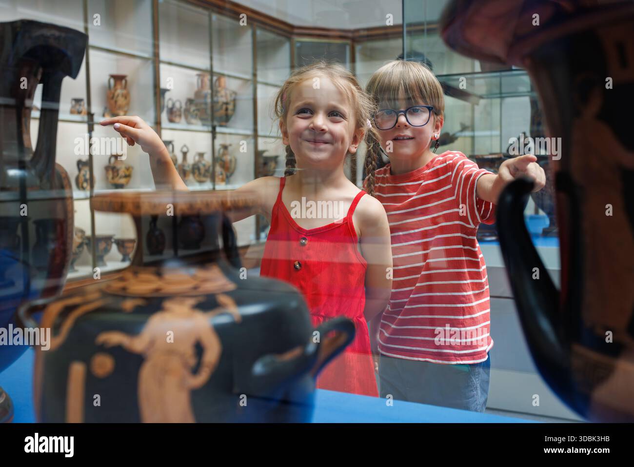 Les enfants explorent un musée, fascinés par la poterie grecque antique Banque D'Images