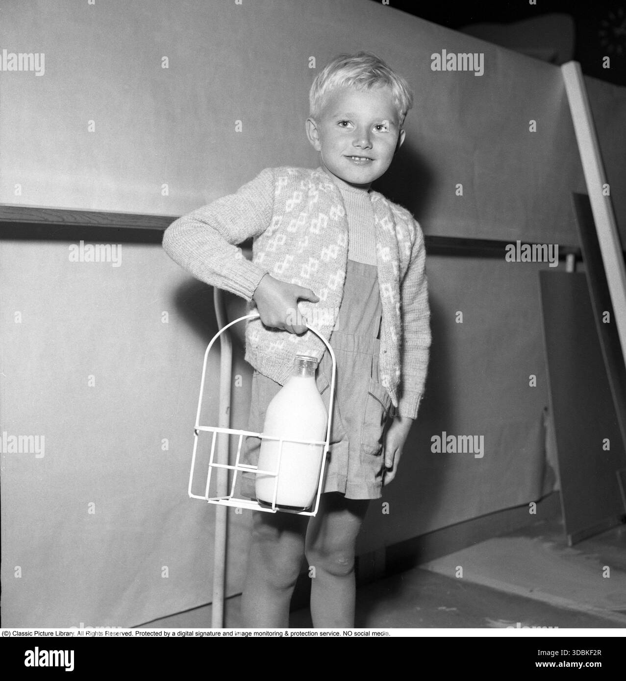 C'est ainsi que vous avez ramené les bouteilles de lait à la maison depuis le magasin 1952. La cage métallique pratique avec poignée avait de la place pour deux bouteilles de lait. Ce sont souvent les enfants qui allaient au magasin et l'achetaient. Dans les années 1950 en Suède, le lait était un symbole de santé et de prospérité. 1952 (Conard réf. 2108) Banque D'Images