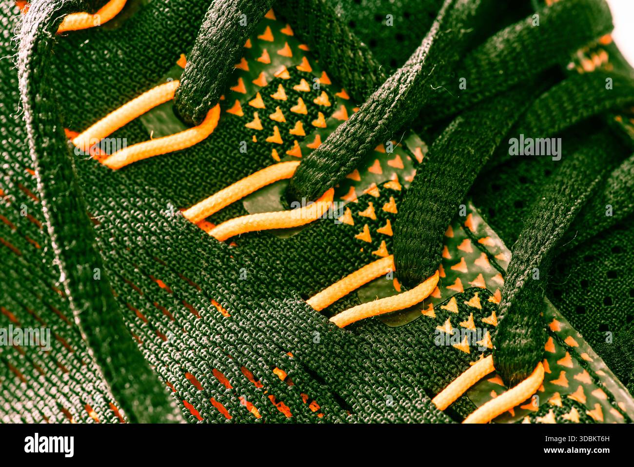 Gros plan extrême d'une chaussure en tissu vert foncé et orange. Banque D'Images