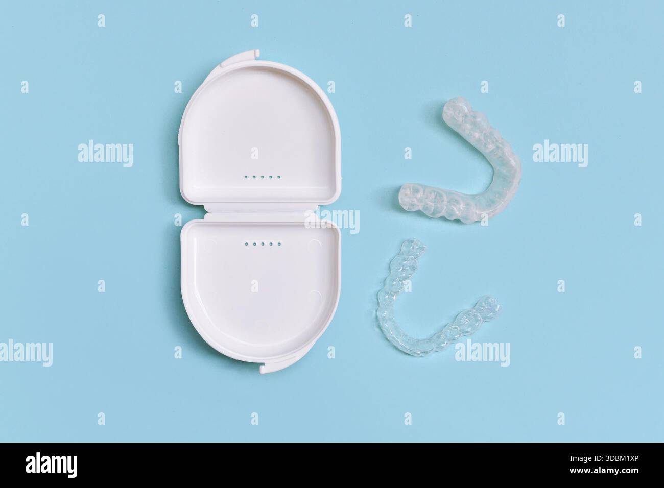 Protège-dents dentaires transparents personnalisés aligners clairs pour la mâchoire inférieure dans un boîtier blanc sur fond bleu Banque D'Images