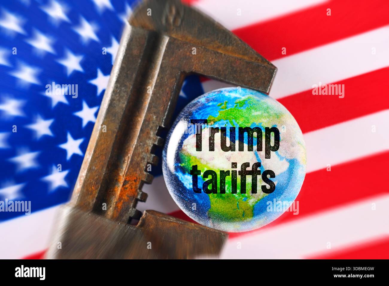 Globe dans la pince avec l’inscription Trump tarifs sur le drapeau américain, photo symbolique pour les tarifs Trump et les conséquences économiques mondiales, photomontage Banque D'Images