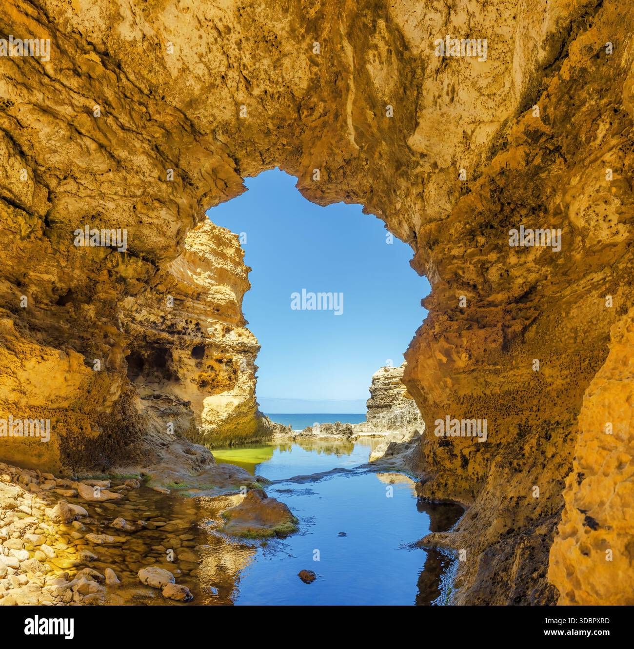 L'arche de calcaire érodée s'ouvre sur l'océan pittoresque encadré par des murs accidentés et un rocher peu profond au premier plan, la Grotto, Great Ocean Road, Australie Banque D'Images