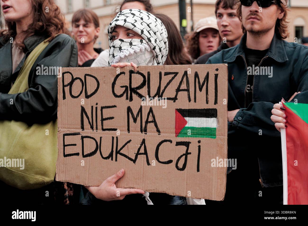 Les manifestants chantent en tenant des drapeaux palestiniens lors d'un rassemblement pro-palestinien près de l'Université de Varsovie. Banque D'Images