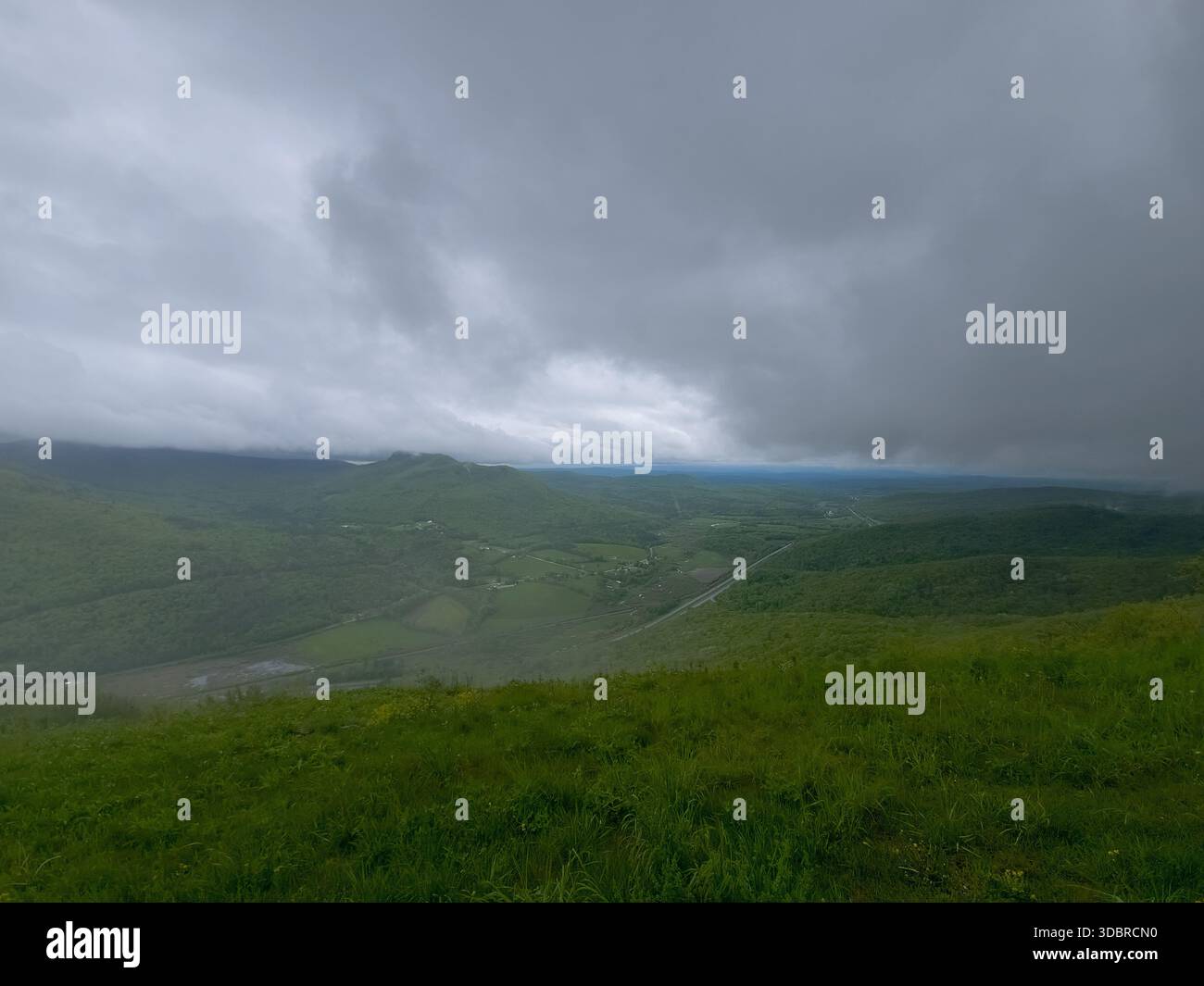 Paysage de vallée de montagne brumeuse sous des nuages spectaculaires Banque D'Images