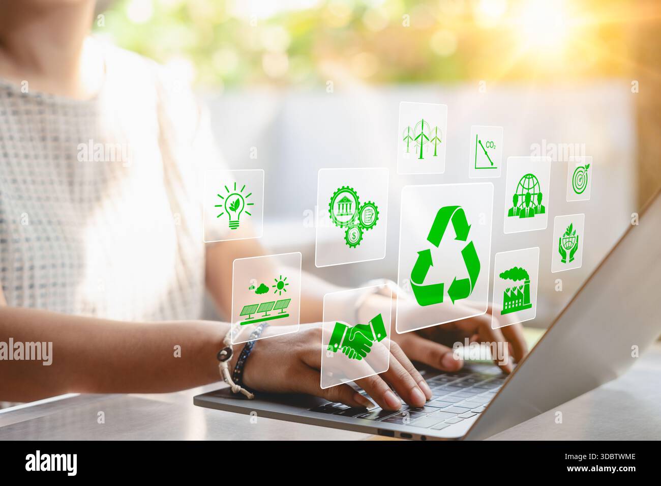 Concept de planification du développement durable. Une femme utilisant un ordinateur portable avec des icônes virtuelles liées au recyclage, aux énergies renouvelables et à la protection de l'environnement Banque D'Images