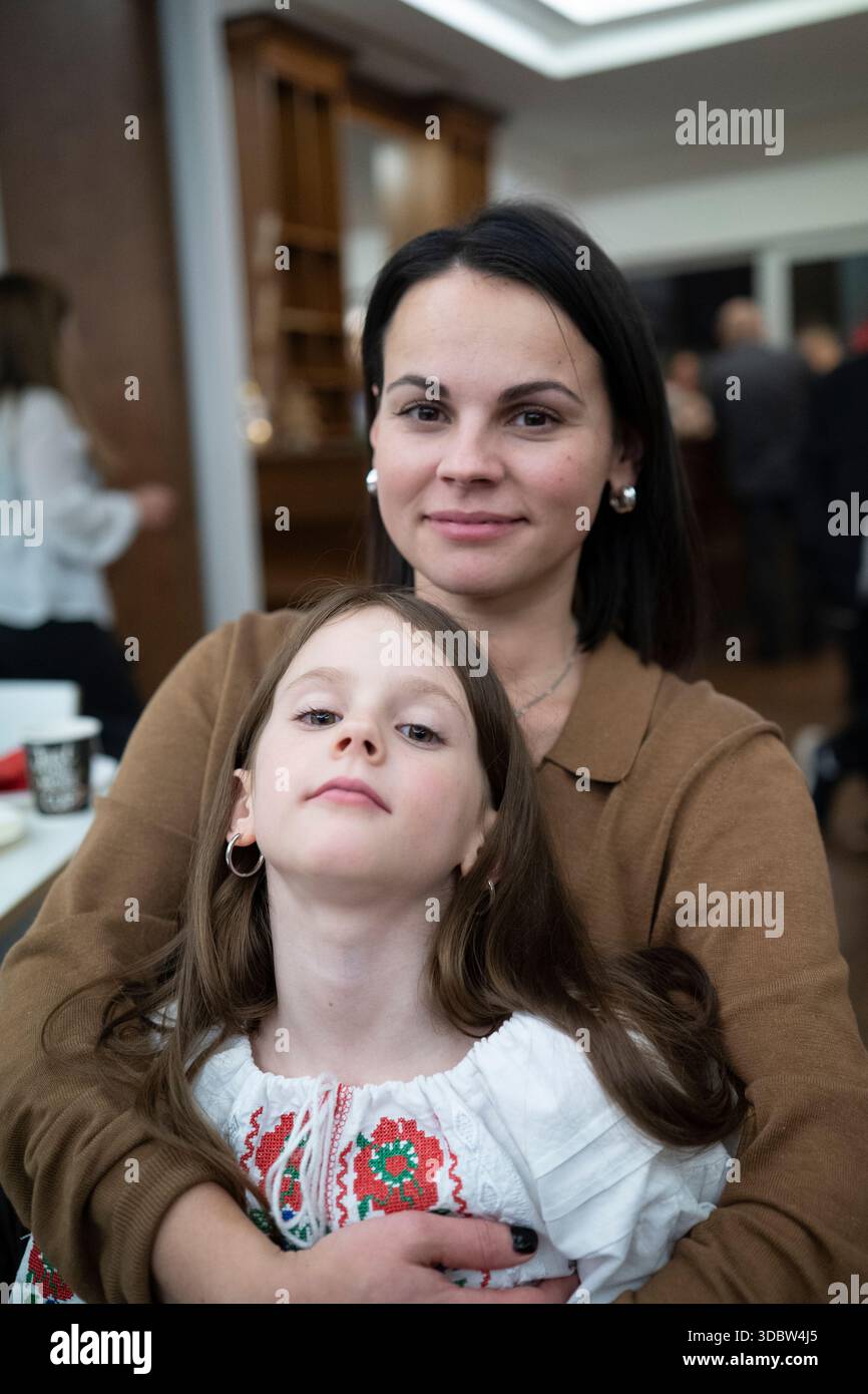 Photo verticale de la mère affectueuse d'âge moyen et sa fille dans vyshyvanka, concept de lien familial émotionnel Banque D'Images
