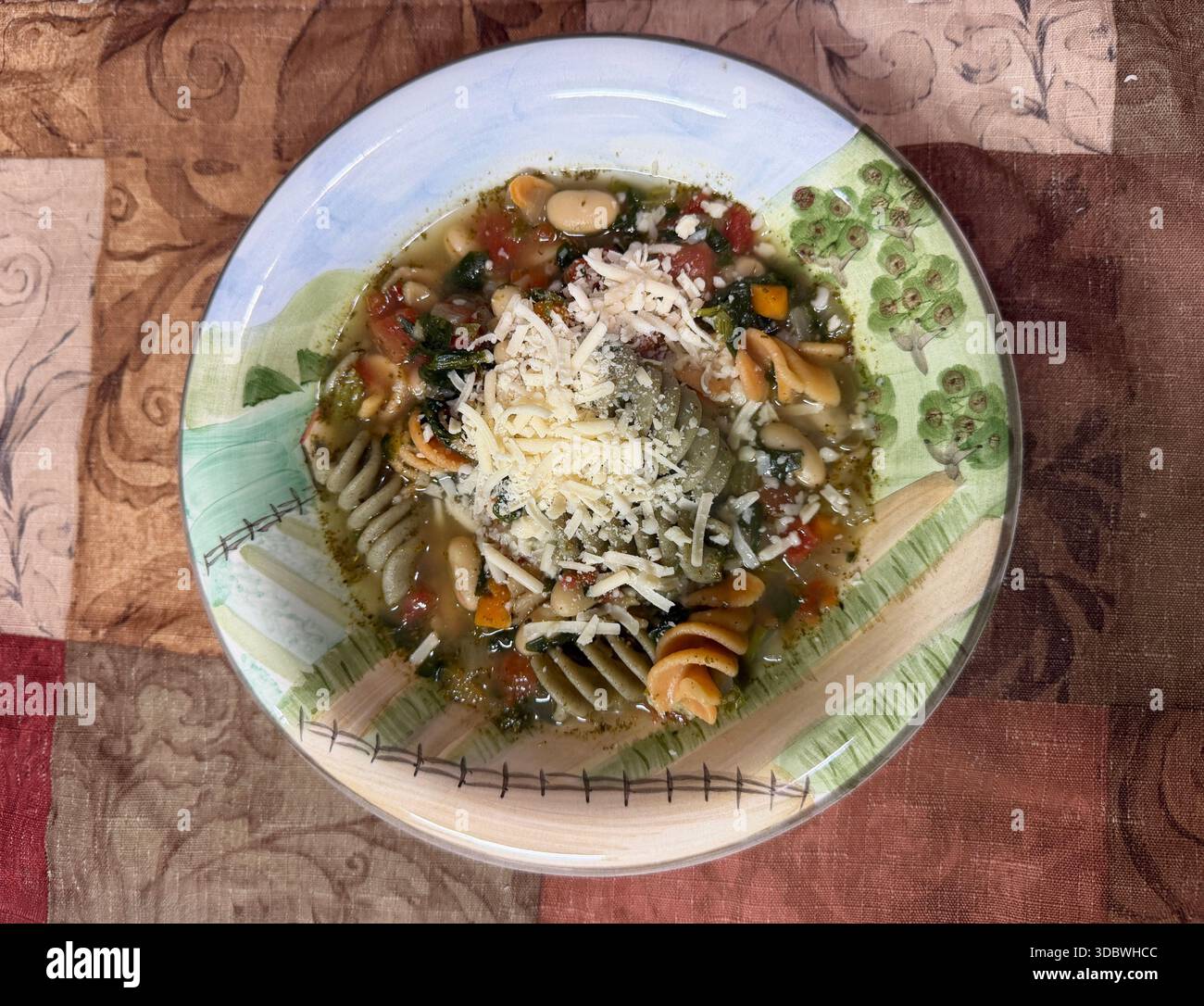 En regardant vers le bas un bol de soupe minestrone salée maison saupoudrée de fromage romano - Image de stock capturée avec un smartphone
