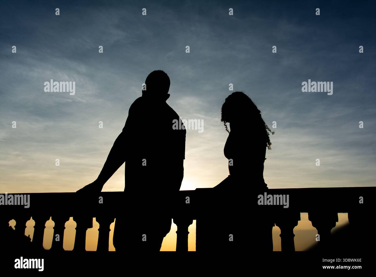 Salvador, Bahia, Brésil - 12 décembre 2025 : la silhouette de deux personnes est vue marcher pendant le coucher du soleil sur la plage de Barra à Salvador, Bahia. Banque D'Images