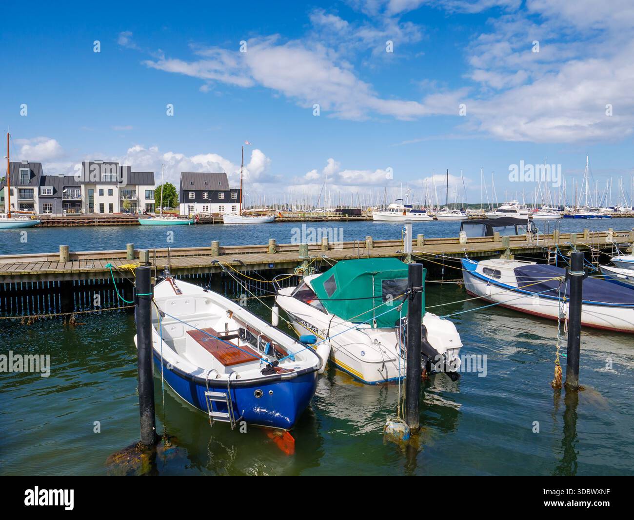 Petits bateaux à moteur dans le port de Kerteminde avec des maisons en bord de mer le long de Nordre Havnekaj en arrière-plan, Funen, Danemark du Sud Banque D'Images
