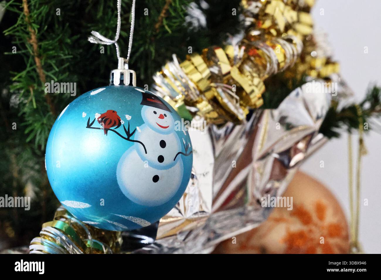 Boule de Noël bleue avec bonhomme de neige sur arbre Banque D'Images