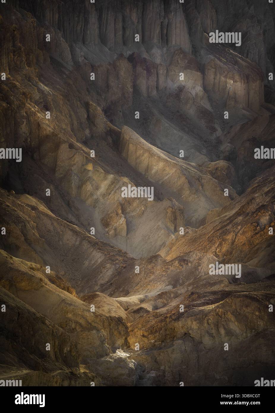 Vue sur le paysage érodé révèle une tapisserie de tons chauds de terre, sculptés par le temps et la météo, dans la vallée de la mort, Californie, États-Unis. Banque D'Images