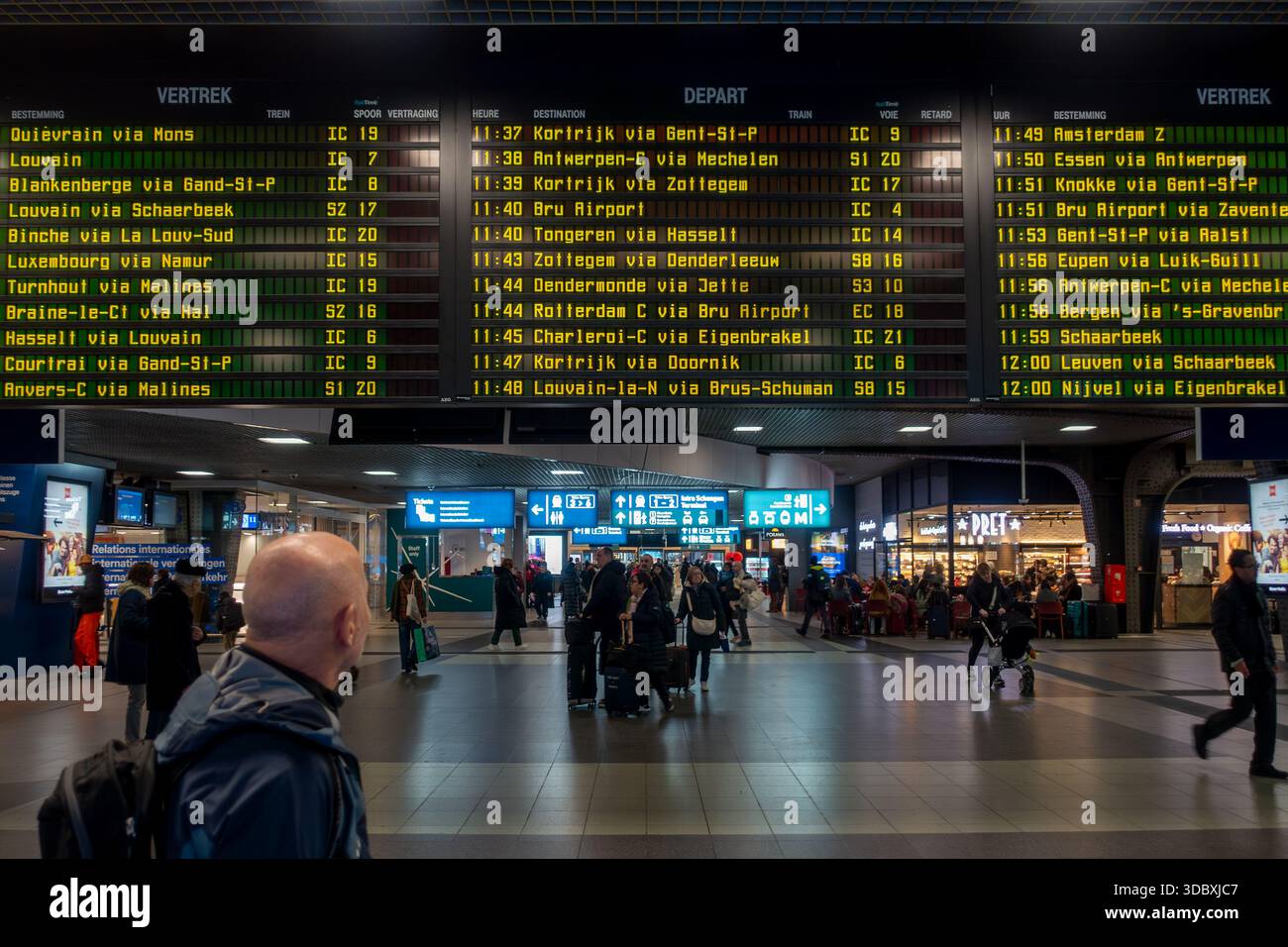 Banlieue / touriste regardant les départs de train dans le hall des départs de la gare NMBS Bruxelles-Sud / Gare de Bruxelles-midi, Belgique Banque D'Images