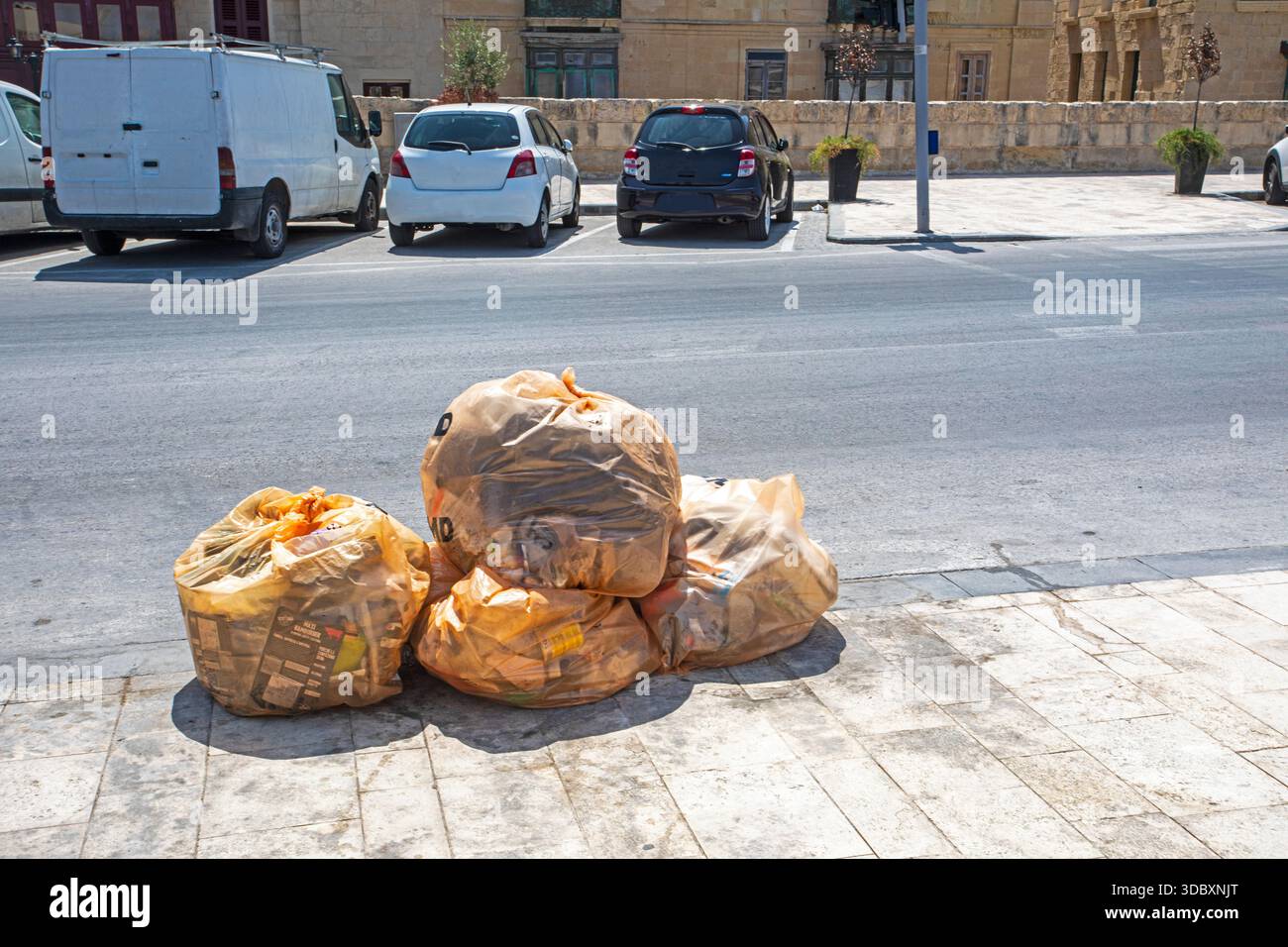 Sacs poubelle avec des ordures sur le trottoir à Valleta, Malte. Protection de l'environnement Banque D'Images